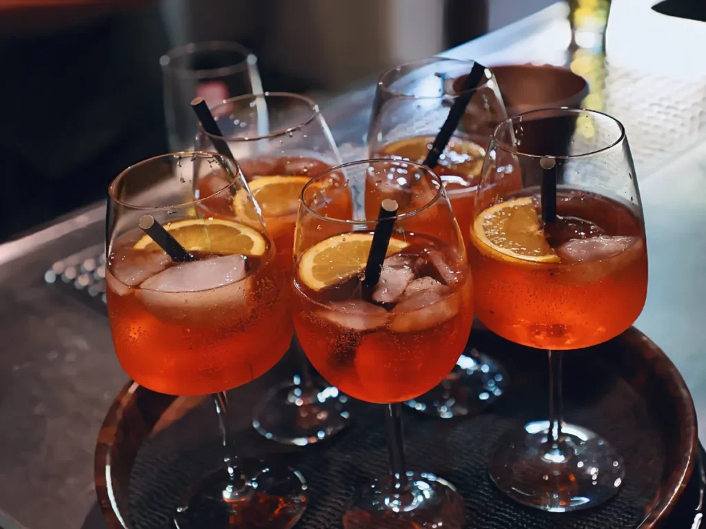 Five glasses of cocktails with lemon on the table.