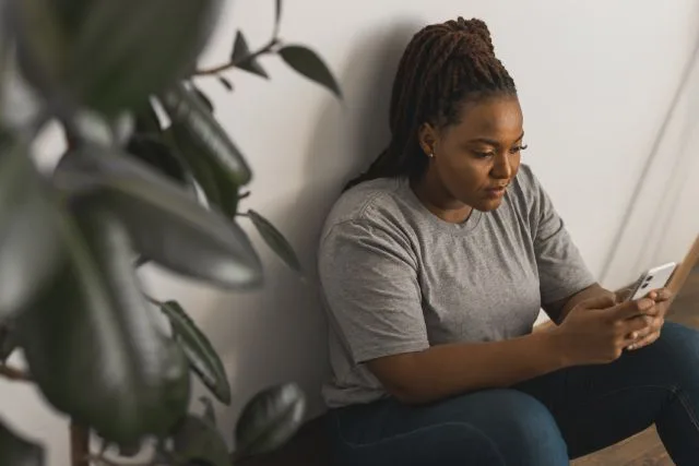 A woman attending her 36-hour DUI treatment through her phone on her break.