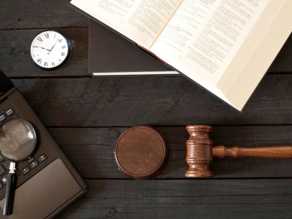 Overhead shot of a wooden desk with objects related to law and time.