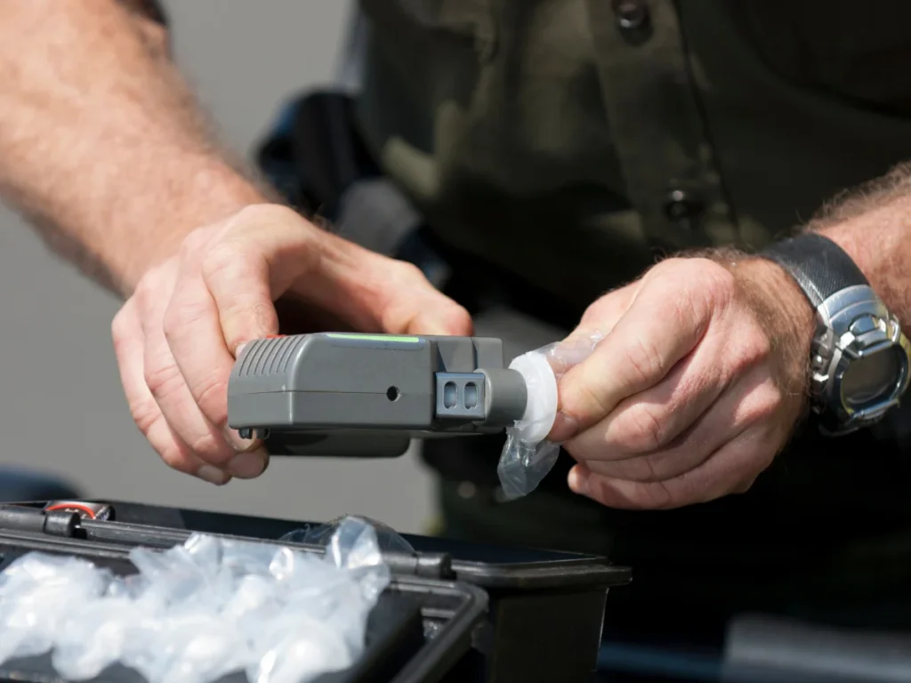 Officer testing an interlock device for a screening.